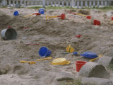 A Childs Colorful Toys are Scattered Throughout a Sand Box Photographie par Roy Gumpel