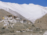 A Tibetan Temple is Built Atop a Hill with the Himalaya Mountains as a Backdrop Photographie par Monika Klum