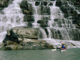A Woman Paddles Her Kayak Next to a Waterfall Photographic Print by Bill Hatcher