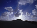 Sunlight Striking Fluffy Clouds Above Sand Dunes Photographic Print by Jason Edwards