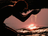 A Person Dips His Hands in the Headwaters of the Mississippi River Photographie par Sam Kittner