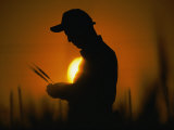 Silhouetted Botanist Examining Grain Photographic Print by Steve Raymer