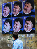 Passerby Looking at Political Posters on Wall, Tyre, Lebanon Photographic Print by Bethune Carmichael