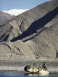 A Boatman Rows a Yak Skin Boat Across the Lhasa River Photographic Print by Gordon Wiltsie