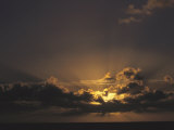 Rays of Sunlight Beam from Behind a Cloud at Sunset over Water Photographic Print by Tim Laman