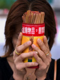 Woman Holding Prayer Sticks at Wong Tai Sin Temple, Kowloon, China Photographie par Michael Coyne