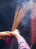 Worshipper Burning Incense in the Wong Tai Sin Temple, Kowloon, China Photographie par Michael Coyne