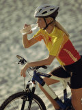 Young Woman Drinking Water While Sitting on a Bicycle Photographic Print