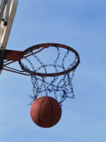 Low Angle View of a Basketball Going Through the Hoop Photographic Print