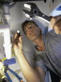 Low Angle View of a Young Man Checking the Plumbing with a Flashlight Lámina fotográfica Low Angle View of a Young Man Checking the Plumbing with a Flashlight Lámina fotográfica