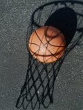 Close-up of a Basketball Resting on The Shadow of a Basketball Hoop Photographic Print