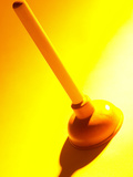 Red Rubber Plumbing Plunger in Yellow Light Photographic Print