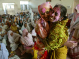 Two Indian Women, with Festive Colored Powder on Their Faces, Embrace and Dance Lámina fotográfica Two Indian Women, with Festive Colored Powder on Their Faces, Embrace and Dance Lámina fotográfica
