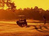 Man and Golf Cart Silhouetted at Sunset Photographie par Bill Bachmann