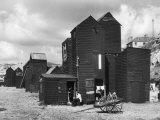 Clustered on the Shingle of the Old Town of Hastings Sussex are These Tall Black Huts Photographic Print by Fred Musto