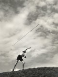 Young Boy Atop a Hill Hurls a Javelin into the Air Photographie