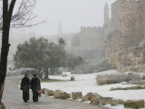 Two Priests Walk in Snow in Front of the Jaffa Gate in Jerusalem's Old City, December 27, 2006 Photographic Print by Oded Balilty