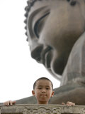 Young Boy in Front of Giant Buddha at Ngong Ping Plateau, China Lámina fotográfica por Holger Leue