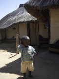 Child by Straw Hut, South Africa Poster von Ryan Ross