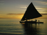 Silhouetted Outrigger Canoe on the Koro Sea Photographic Print by Thomas J. Abercrombie