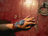 A bracelet is displayed near a red doorway at the Summer Palace in Beijing Lámina fotográfica