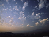 Puffy White Clouds are Backlit by a Setting Sun Photographic Print by Todd Gipstein