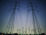 Setting Sun Silhouettes Tall, High-Tension-Wire Towers Photographic Print