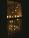 Vue des bougies et d'un sapin de Noël à travers une fenêtre Photographie