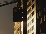 A Traffic Light Near Sunlit High-Rises Shines Red Photographic Print