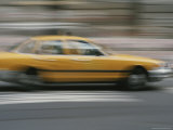 A Yellow Taxi Rushes by on a Busy New York Street Photographie