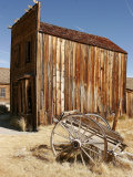 A Wooden Cart Decays in Front of an Abandoned Building Photographic Print by Charles Kogod