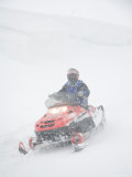 A Woman Drives Along on a Snowmobile in a Blizzard Photographic Print by Taylor S. Kennedy
