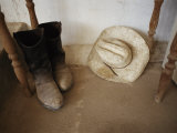 Cowboy Boots and Hat Lie under a Table Photographic Print by Jodi Cobb