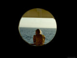 Woman Seen Through the Porthole of a Cruise Ship Looking Out to Sea  Lámina fotográfica