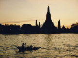 A Man Paddles a Boat Past Wat Arun at Twilight Photographic Print by Dean Conger