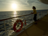 Woman Looking Out to Sea Leaning on the Railing of a Cruise Ship Lámina fotográfica