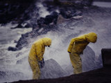 Two Young Boys in Yellow Slickers Play in the Surf Photographic Print by Jodi Cobb