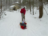 Man Pulling Two Children on a Sled Through the Snow Photographic Print by Todd Gipstein