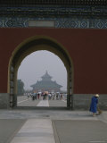A Woman Sweeps a Sidewalk as Sightseers Tour the Forbidden City Photographie