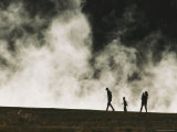 A Silhouetted Family Walks Past a Steaming Hot Springs in the Park Photographic Print by Michael Melford
