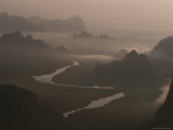 A Winding River Passes Among Jagged Mountains Rimmed with Fog Photographie