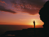 Distant View of a Silhouetted Photographer against a Brilliant Sunset Photographic Print by Richard Nowitz
