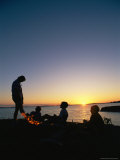 A family is silhouetted around a campfire Lámina fotográfica A family is silhouetted around a campfire Lámina fotográfica