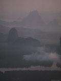 A Winding River Passes Among Jagged Mountains Rimmed with Fog Photographie