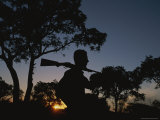 A Silhouetted Man with Rifle Enjoys Sunset at a Private Game Reserve Photographic Print by Tino Soriano