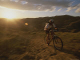 The Sun Sets Behind a Cyclist, out for a Ride on His Mountain Bike Photographic Print by Bobby Model