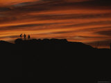 Silhouetted Hikers Set against a Brilliant Sunset Photographic Print by Bobby Model