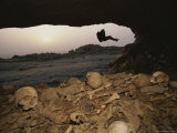 A Rock Climber Rappels into a Cave Littered with Human Remains Photographie