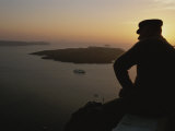 A Silhouetted Greek Man Enjoys a Sunset from a High Point on Thira Photographic Print by Tino Soriano