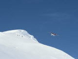 A Twin Otter plane flies over ski mountaineers atop Detroit Plateau Lámina fotográfica A Twin Otter plane flies over ski mountaineers atop Detroit Plateau Lámina fotográfica
